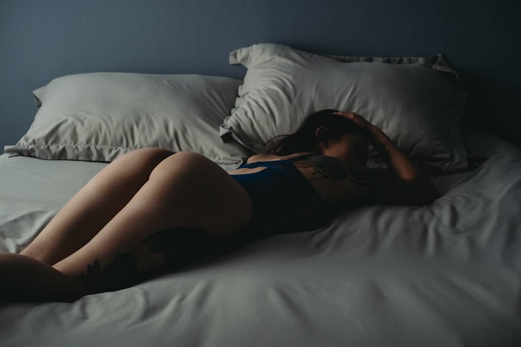 Woman lying on the bed, showcasing her booty wearing a blue bodysuit. Photo by Embodied Art Boudoir. Boudoir images, powerful women, sexy at any weight, body confidence, body image, self love, self confidence, changes, confident women, self care practices, challenge yourself, boudoir inspiration, boudoir images, colorado boudoir, denver boudoir, boulder boudoir, colorado springs boudoir, female photographer, body positive studio

