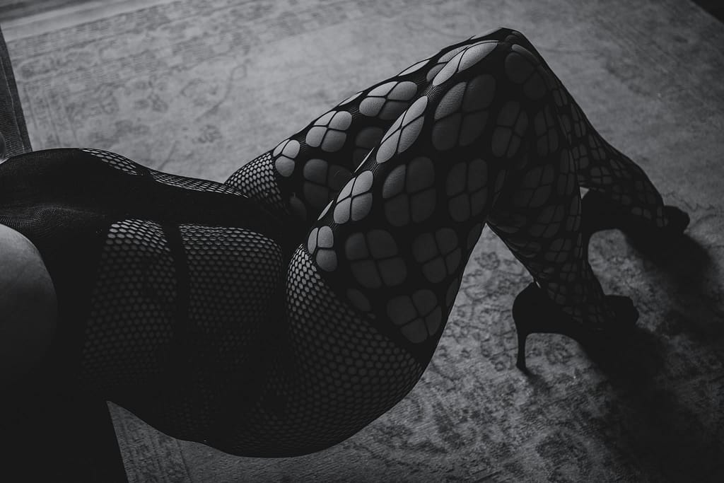 Woman lying down wearing fishnet body suit and stockings. Photo by Embodied Art Boudoir. Boudoir images, powerful women, sexy at any weight, body confidence, body image, self love, self confidence, changes, confident women, self care practices, challenge yourself, boudoir inspiration, boudoir images, colorado boudoir, denver boudoir, boulder boudoir, colorado springs boudoir, female photographer, body positive studio

