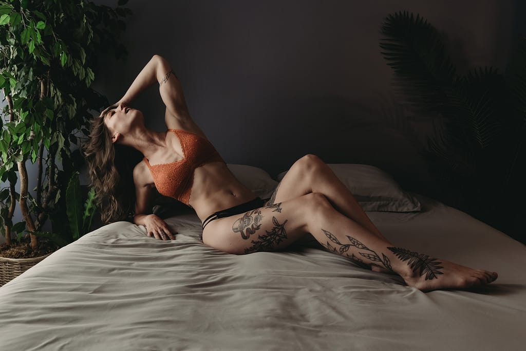 Woman lying on bed, wearing a orange bra and black panties. Photo by Embodied Art Boudoir. Mindful, mindfulness, brain and body, brain body connection, yoga, pause, live in the moment,  intention, journal, self expression, confidence, express yourself, embodied, boudoir photos,  colorado boudoir, denver boudoir, boulder boudoir, colorado springs boudoir