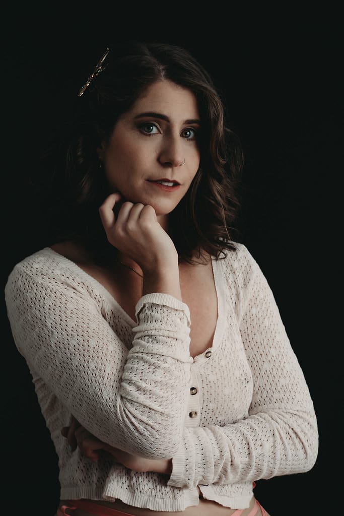 Woman standing looking curiously at the camera, with hand gently resting on face wearing a white sweater. Photo by Embodied Art Boudoir. Modest boudoir photography, Modest Fashion, Modest Woman, Fashion Trends, Shy, classy photography, classic boudoir, classy boudoir, feminine photography, colorado boudoir, denver boudoir, boulder boudoir, colorado springs boudoir, boudoir ideas, boudoir poses, boudoir inspiration, photography inspiration, boudoir session, boudoir photos
