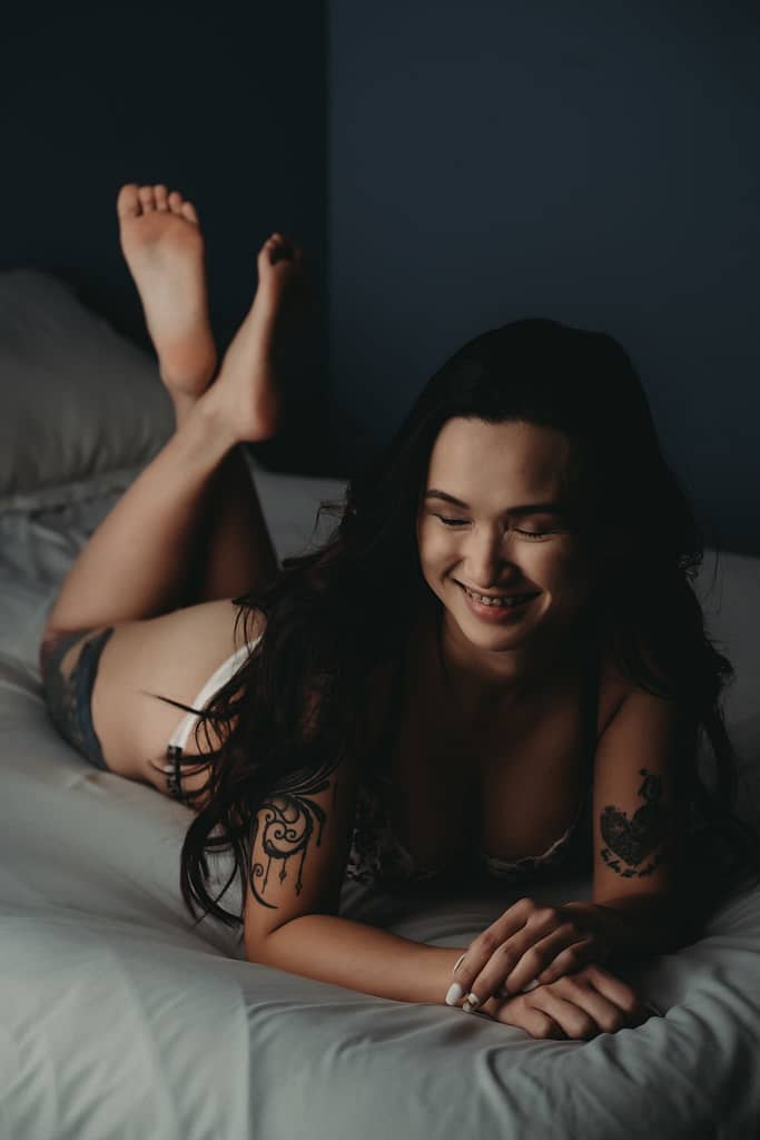 Photo of woman lying on the bed, with legs crossed. Photo by Embodied Art Boudoir, boudoir posing, boudoir inspiration, plus size photography, plus size boudoir, plus size glamour, plus size posing, plus size outfits, fat boudoir, fat empowerment, body positivity, fat positive, body positive, body confidence, body empowerment, haes, colorado boudoir, denver boudoir 