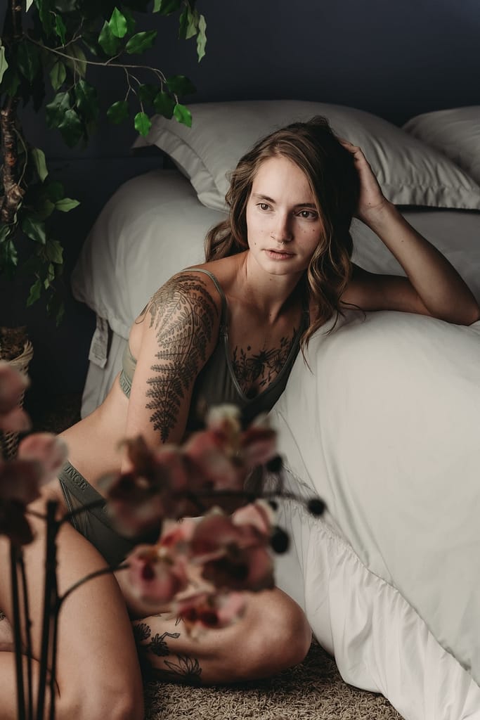 Woman sitting next to bed, wearing green matching underwear. Photo by Embodied Art Boudoir. Ethical shopping, ethical lingerie, sustainability, empowerment, shop sustainable, vote with your money, environmentally conscious, a living wage, lingerie piece, beautiful lingerie, shopping inspiration, mindfulness, boudoir lingerie, shop well, colorado boudoir, denver boudoir, boulder boudoir, colorado springs boudoir, boudoir ideas
