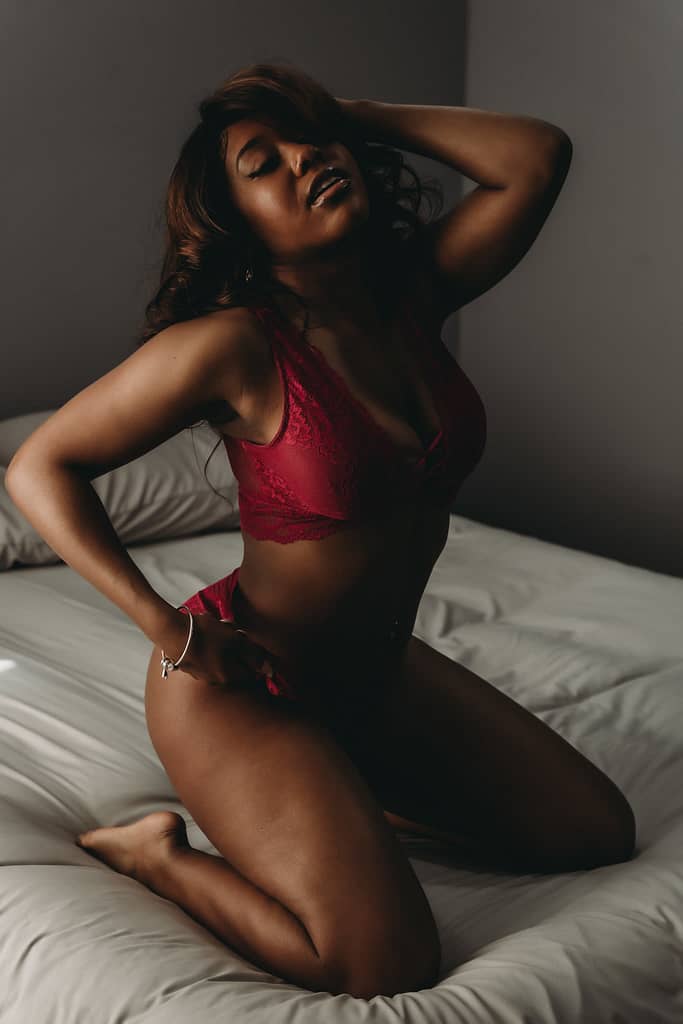 Woman kneeling on bed wear9ing a matching deep red bralette and panties. Photo by Embodied Art Boudoir, black owned business, lingerie stores, people of color owned business, POC business, BIPOC business, successful females, business shout out, lingerie must haves, buy local, support your community, your money is a vote, black lives matter, colorado boudoir, denver boudoir, boulder boudoir, colorado springs boudoir, boudoir ideas, boudoir photography, photography inspiration 
