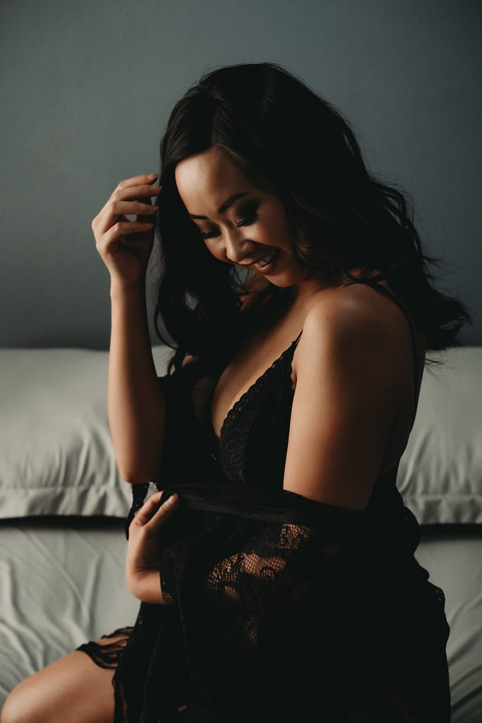 Woman sitting on bed weaing an off shoulder black robe. Photo by Embodied Art Boudoir, cozy, cozy boudoir, cozy vibes, cozy outfits, cozy and comfortable, cozy boudoir photography, cozy inspiration, keep it cozy, boudoir outfit, boudoir outfit inspiration, what to wear to boudoir, colorado boudoir, denver boudoir, boulder boudoir, colorado springs boudoir, boudoir ideas, boudoir poses, boudoir inspiration, photography inspiration