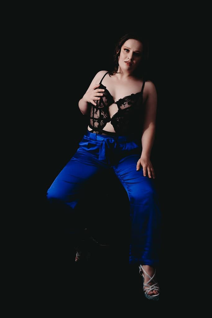 Woman sitting on stool wearing bright blue pants and a black lacy top. Photo by Embodied Art Boudoir. Boudoir images, boudoir bonus, bonus set, printed photos, shower set, photo album, bedsheet, whips and chains, boudoir inspiration, timeless, collection, confidence, remember forever, good deal, priceless, invest in your self, treat yourself, female photographer, female boudoir photographer, empowering women, colorado boudoir, denver boudoir, boulder boudoir, colorado springs boudoir, boudoir ideas, boudoir poses, boudoir inspiration, photography inspiration
