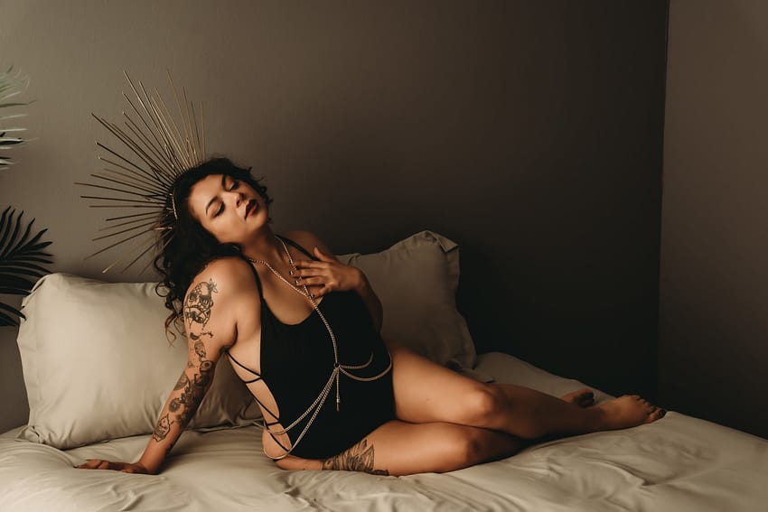 Woman lying on the bed wearing a stringy black body suit and crown on head. Photo by Embodied Art Boudoir. Boudoir outfits, boudoir lingerie, boudoir fashion, boudoir babes, boudoir inspo, boudoir fashion, boudoir dress, boudoir style, personal style, favorite outfits, blogging, boudoir ideas, lingerie, colorado boudoir, boudoir, denver boudoir, denver boudior, boulder boudoir, colorado springs boudoir, boudoir ideas, photoshoot accessories, outfit inspiration, photoshoot outfit
